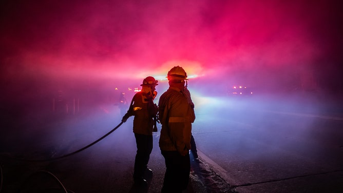 A firefighter fights the Franklin Fire while it burns in the Pacific Coast Highway in the morning on December 11, 2024 near Malibu, California.