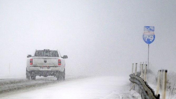 Cars drive through nearly white lake-effect snow on Interstate 79 on December 12, 2024 in Erie, Pennsylvania.