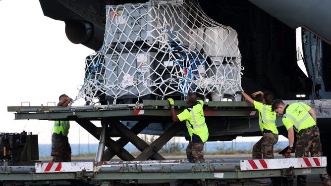 French military unload medical and emergency equipment from the A440M military aircraft, aboard of wich rescue teams were transported in an emergency response, bringing aid to the small French Indian Ocean territory of Mayotte, almost cut off from the world after the passage of cyclone Chido, at the French Air Force Base 181 Saint-Denis-La Reunion "Lieutenant Roland Garros" in Sainte-Marie, on the French Indian Ocean island of La Reunion, on December 15, 2024. At least 14 people were killed in Mayotte when a fierce cyclone battered the territory, authorities said, with officials warning it will take days to know the full toll. Rescue workers and supplies are being rushed in by air and sea, but their efforts are likely to be hindered by damage to airports and electricity distribution in a territory where even clean drinking water was already subject to chronic shortages. 