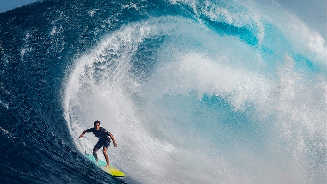 Surfer Tai Kane catches a wave at the famous Pe'ahi Jaws Surf Break on the island of Maui, Hawaii on December 20, 2024.