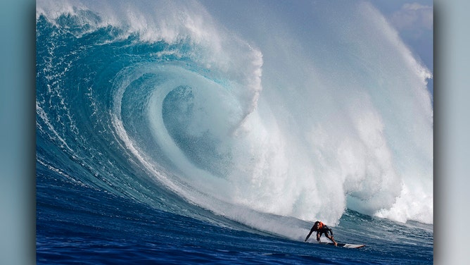 Hawaiian surfer Noah Beschen catches a wave at the Pe'ahi Jaws Surf Break on the island of Maui, Hawaii, on December 21, 2024.