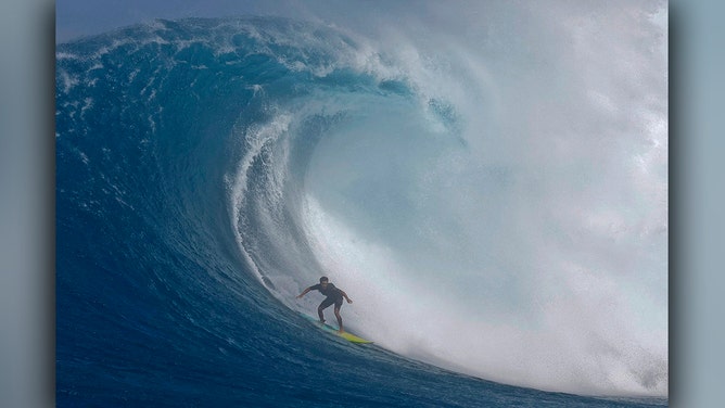 Hawaiian surfer Tai Kane catches a wave at the Pe'ahi Jaws Surf Break on the island of Maui, Hawaii, on December 21, 2024.