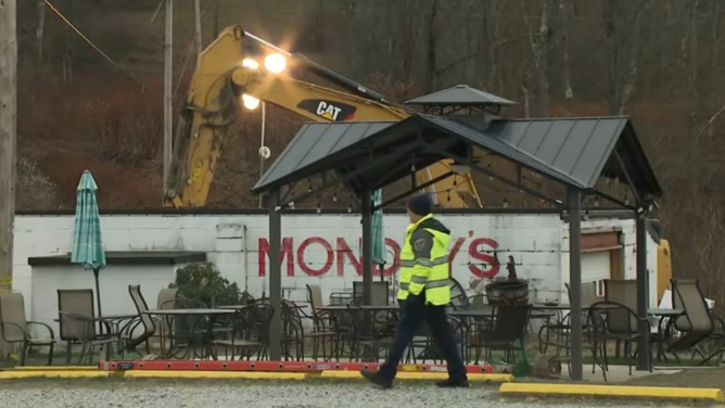 Specialized equipment moving dirt around the sinkhole behind the restaurant.