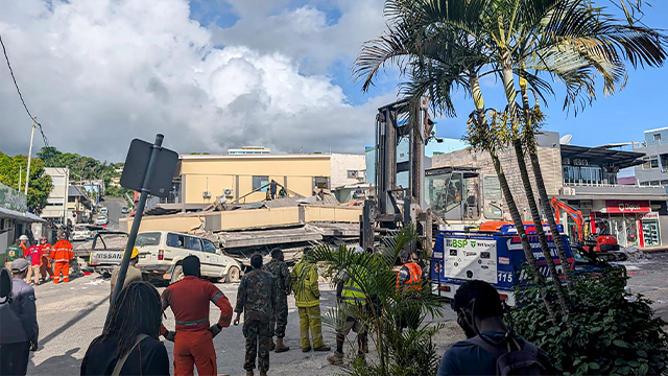 Rescue workers are seen at the site of a collapsed building after a powerful earthquake struck Port Vila, the capital city of Vanuatu, on December 17, 2024. A powerful earthquake hit the Pacific island of Vanuatu on December 17, smashing buildings in the capital Port Vila including one housing the US and other embassies, with a witness telling AFP of bodies seen in the city. (Photo by AFP) (Photo by STR/AFP via Getty Images)