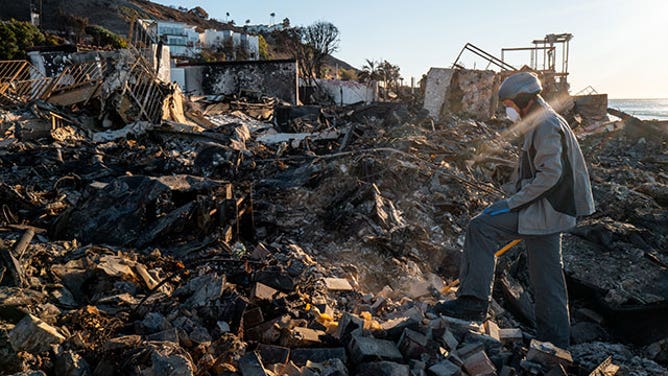 Patrick O'Neal sifts through his home after it was destroyed by the Palisades wildfire on January 13, 2025 in Malibu, California.