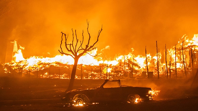 2025 年 1 月 8 日、カリフォルニア州ロサンゼルスのパシフィック パリセーズ地区で、大嵐が発生し、パリセーズ火災による炎が車と家を焼きました。