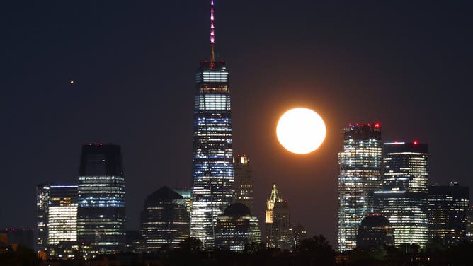 NEWARK, NJ - OCTOBER 2: The moon rises along with Mars behind lower Manhattan and One World Trade Center in New York City, a day after the full Harvest Moon on October 1, 2020 as seen from Newark, New Jersey.