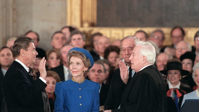 President Ronald Reagan (C) is sworn in as 40th President of the United States by Chief Justice Warren Burger (R) beside his wife Nancy Reagan (C) during inaugural ceremony, on January 21, 1985 in the Capitol Rotunda in Washington D.C.