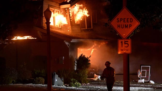 Pasadena, CA - January 08: A home burns down on the 2700 block of Woodlyn Rd at Washington Blvd. as LA County Firefighters try to save it during the Eaton Fire in Pasadena on Wednesday, January 8, 2025.