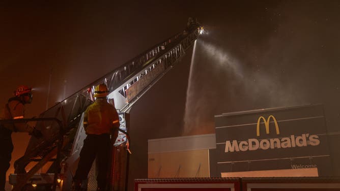 PASADENA, CALIFORNIA - JANUARY 7: Firefighters battle the Eaton Fire as a McDonald's fast food restaurant burns on January 7, 2025 in Pasadena, California. A powerful Santa Ana wind event has dramatically raised the danger of wind-driven wildfires such as the dangerous and destructive Palisades Fire near Santa Monica. The strong winds also forced President Joe Biden to cancel his plan to travel between Los Angeles and Riverside, California.