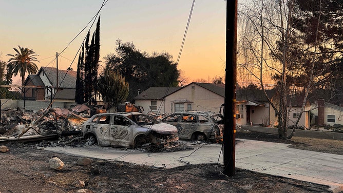 Burnt out cars next to a home that was untouched during the Eaton Fire in Altadena on Friday, January 10, 2025.