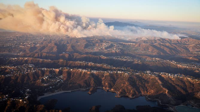 Flames from the Palisades Fire burn along the ridge line near Mandeville Canyon while fire crews attempt to prevent northern expansion toward homes around and into the San Fernando Valley in Los Angeles, Calif. on Saturday, Jan. 11, 2024. The fire has set in place new evacuation warnings and can be seen near Encino and Tarzana neighborhoods. (Photo by Brontë Wittpenn/San Francisco Chronicle via Getty Images)