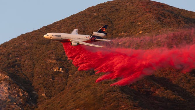 A plane drops fire retardant during the Eaton Fire near Altadena, California, US, on Monday, Jan. 13, 2025. Southern California faces another round of dangerous fire weather set to begin Monday night, even as crews struggle to contain wind-driven blazes that have paralyzed Los Angeles for nearly a week and killed at least 24 people. Photographer: Benjamin Fanjoy/Bloomberg via Getty Images