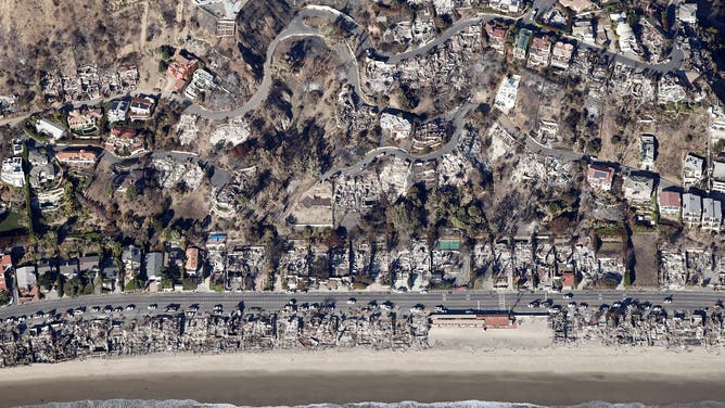 MALIBU, CALIFORNIA - JANUARY 13: An aerial view of utility vehicles parked near beachfront homes destroyed in the Palisades Fire as wildfires cause damage and loss through the LA region on January 13, 2025 in Malibu, California. Multiple wildfires fueled by intense Santa Ana Winds continue to burn across Los Angeles County, with some containment achieved. According to reports, 24 people have died with over 180,000 people under evacuation order or warning. Over 12,000 structures have been destroyed or damaged, while more than 35,000 acres have burned. (Photo by Mario Tama/Getty Images)