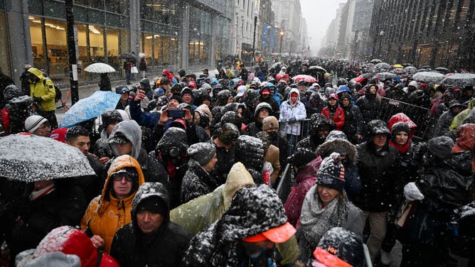 Attendees stand in the snow outside a rally with US President-elect Donald Trump, not pictured, at Capital One Arena ahead of the 60th presidential inauguration in Washington, DC, US, on Sunday, Jan. 19, 2025.