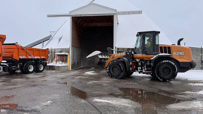 Trucks for the The Department of Public Works Division of Streets and Road Operations load salt to prepare for treating roads.