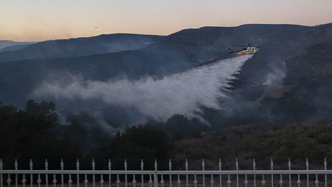 CALIFORNIA, USA - JANUARY 10: Firefighting planes and helicopters dump water on flames during the Kenneth Fire in West Hills, Los Angeles, California, United States on January 10, 2025. (Photo by Jon Putman/Anadolu via Getty Images)