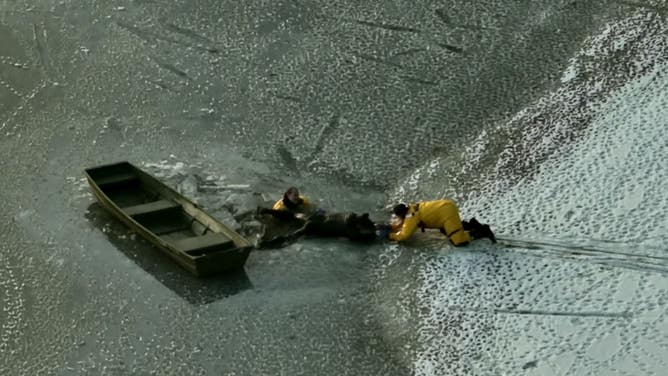 Firefighters help pull the man out of the icy lake. 