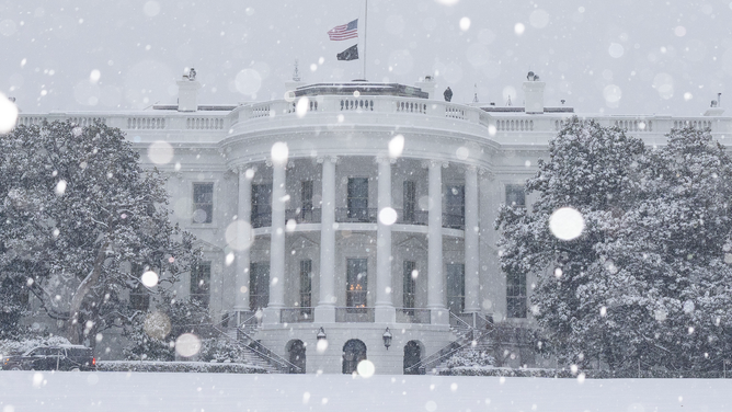 Snow falls in Washington, D.C., on Monday as a winter storm snarls travel across the nation.