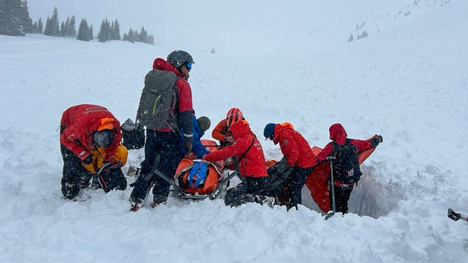 Rescuers placing man on a gurney.
