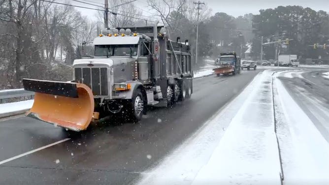 Snowplows drive down a road in Virginia on Feb. 19, 2025.