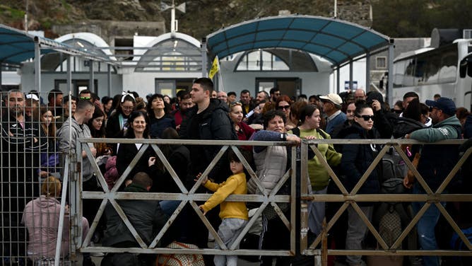 People are waiting for the quay to embark on a ferry in the harbor on the Greek island of Santorini on February 3, 2025 as they prepare to leave in the wake of recurring earthquakes. Fresh night over shaking shaking Greece's top tourist island Santorini, says media reports, causing people to sleep outdoors and others to leave flights or ferry. (Photo of ARIS MESSINIS / AFP)