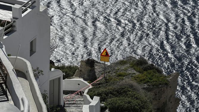 この写真は、2025年2月5日にギリシャのサントリーニ島にあるジン村での最近の地震活動からの予防策として、観光客へのアクセスを制限するカセットの警告を示しています。