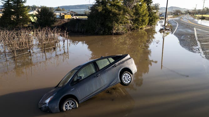 この車両は、2025年2月5日水曜日、カリフォルニア州ソノマのシェルビル近くの川近くの川の大気の後、州道121沿いの洪水に部分的に浸されています。