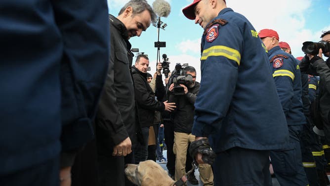 ギリシャ・キリアコス・ミツゾアコタキス首相（L）は、2月7日にサントリーニ島のフィラ市のギリシャ消防署の救助チームを訪問中に説明するときに、ゴールデンレトリバーの救助犬を見ています。 、2025