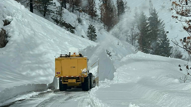 This image shows crews working to clear snow from an avalanche from State Highway 21 in Idaho.
