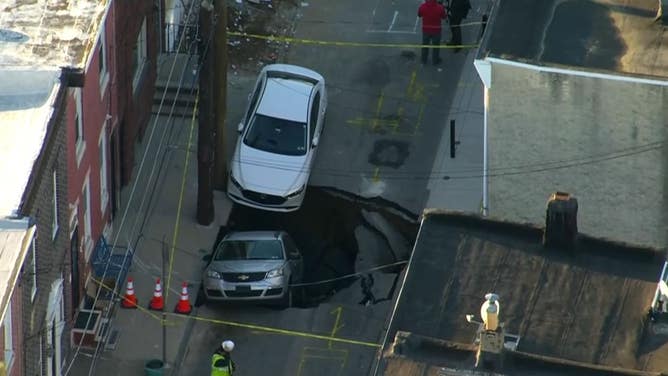 A sinkhole swallows cars in Philadelphia after a water main break.