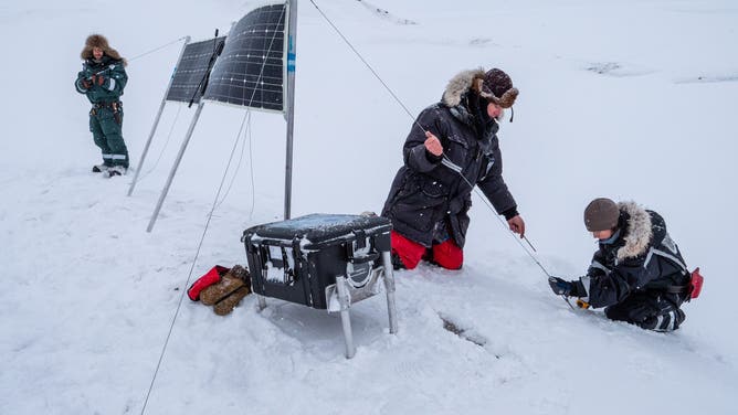 Researchers setting up the remote cameras in Svalbard for the maternal den study.