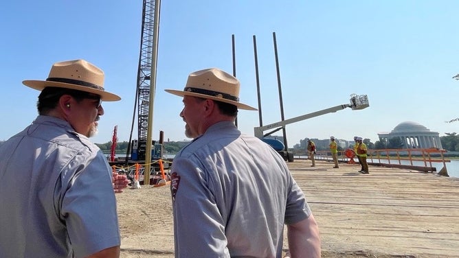 National Park Seeinrvice Director Chuck Sams and National Mall and Memorial Parks Superintendent Jeff Reinbold observe repairs along the Tidal Basin.