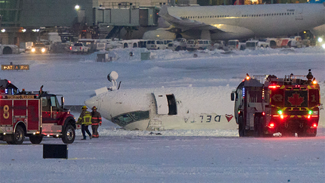 A Delta airlines plane sits on its roof after crashing upon landing at Toronto Pearson Airport in Toronto, Ontario, on February 17, 2025. A Delta Air Lines jet with 80 people onboard crash landed Monday at the Toronto airport, officials said, flipping upside down and leaving at least 15 people injured but causing no fatalities. The Endeavor Air flight 4819 with 76 passengers and four crew was landing at around 3:30 pm in Canada's biggest metropolis, having flown from Minneapolis in the US state of Minnesota, the airline said. (Photo by Geoff Robins / AFP) (Photo by GEOFF ROBINS/AFP via Getty Images)