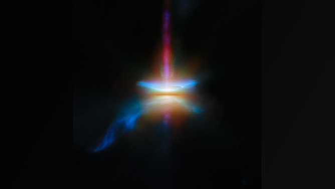 A close-in image of a protoplanetary disc around a newly formed star. A dark line across the center is the disc, corresponding to the densest parts of the disc, made of opaque dust: the star is hidden in here and creates a strong glow in the center. A band going straight up is a jet, while other outflows above and below the disc, and a tail coming off to one side.