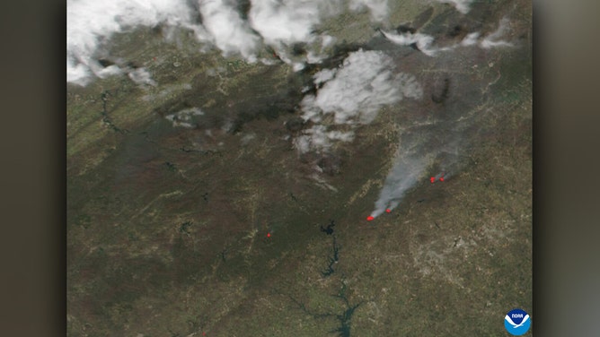 Wildfire smoke, captured by the Visible Infrared Imaging Radiometer Suite (VIIRS) onboard the NOAA/NASA Suomi-NPP satellite on March 23, 2025, is visible over parts of North Carolina and South Carolina. The image shows plumes of smoke billowing northeast and red data points indicating active fires.