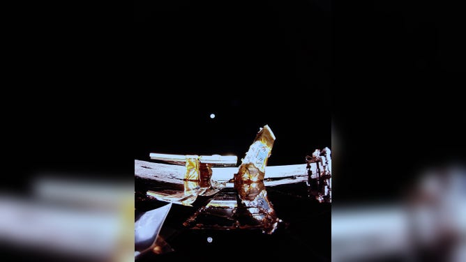 This image shows the Moon's surface, Earth on the horizon, and Blue Ghost's top deck with its solar panel, X-band antenna (left), and LEXI payload (right) in the view.