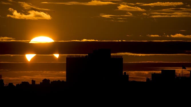 A partial Solar eclipse is seen just after sunrise over the Queens borough of New York across the East River on November 3, 2013 in New York. AFP PHOTO/Stan HONDA (Photo credit should read STAN HONDA/AFP via Getty Images)