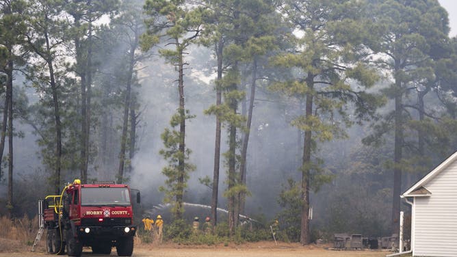 MYRTLE BEACH, SOUTH CAROLINA - MARCH 2: Firefighters battle a blaze in the Carolina Forest neighborhood on March 2, 2025 in Myrtle Beach, South Carolina. Multiple forest fires in the area have caused evacuations along the South Carolina coast.
