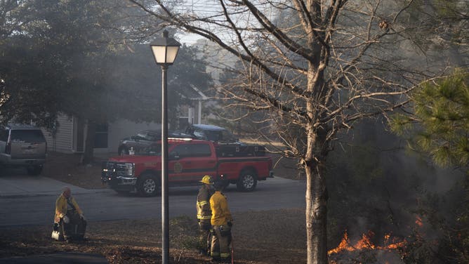 MYRTLE BEACH, SOUTH CAROLINA - MARCH 02: Firefighters attend to a flare-up in the Carolina Forest neighborhood on March 2, 2025 in Myrtle Beach, South Carolina. Multiple forest fires in the area have caused evacuations along the South Carolina coast.