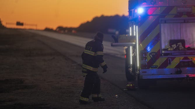 WESTHAMPTON, NEW YORK - MARCH 08: A firefighter returns from a forest fire along Route 27 on March 8, 2025 in Westhampton, New York. As strong winds fueled multiple brush fires on New York's Long Island, closing roads and reportedly burning structures. (Photo by Andrew Theodorakis/Getty Images)