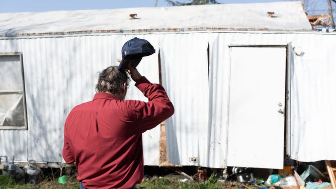 Tim Striegel looks at his damaged home the morning after his mobile home was hit by a tornado on March 16, 2025 in Calera, Alabama. According to reports, two people have been killed and over 50 counties in Alabama have reported damage, and more than 30 people have been killed across the south due to massive storms.