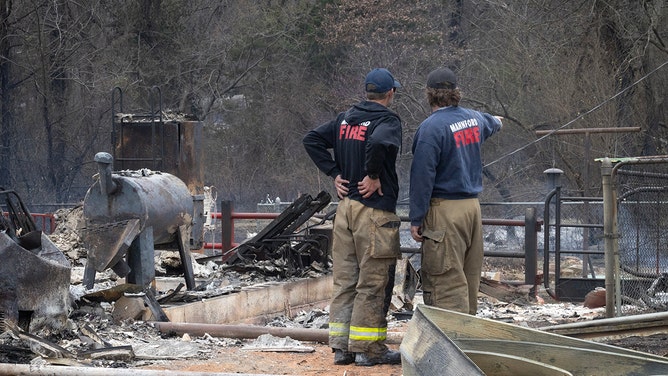 Firefighters survey damage to a home destroyed by yesterday's wildfire as they continue to extinguish hotspots on March 15, 2025 in Mannford, Oklahoma.