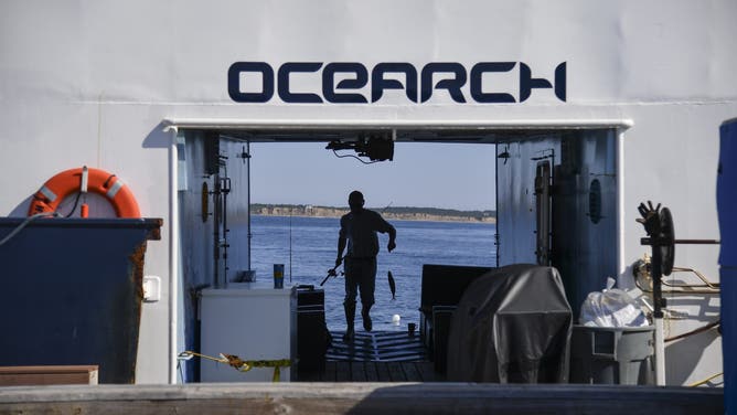 MONTAUK, NY - AUGUST 9: Deckhand DJ Lettieri walks with a mackerel fish which is used for bait and chum to catch shark aboard the OCEARCH research boat just offshore in the Atlantic Ocean on August 9, 2017 in Montauk, N.Y. 