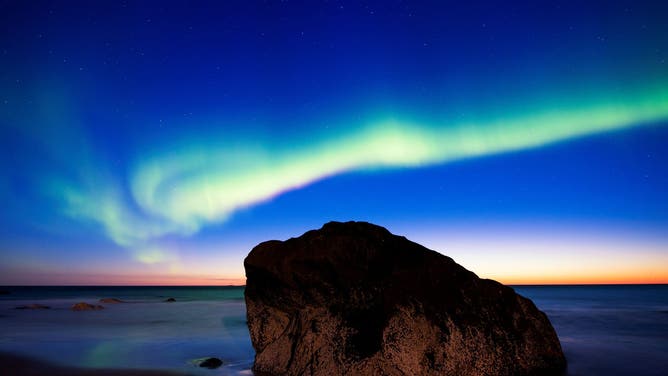 Northern lights ( aurora borealis ) illuminate the sky over Uttakleiv beach near Leknes, on Lofoten Islands, Arctic Circle, on September 8, 2017.