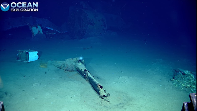 More pieces of metal and debris lay along the ocean floor.