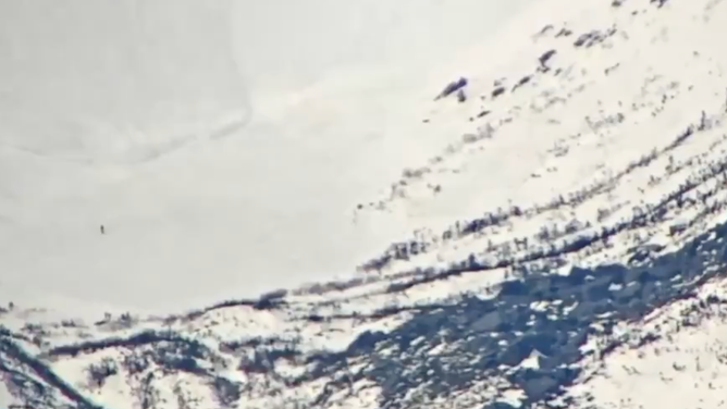 A screenshot of a video captured by the Mountain Washington Observatory in New Hampshire shows a snowboarder racing ahead of an avalanche in Tuckerman's Ravine.