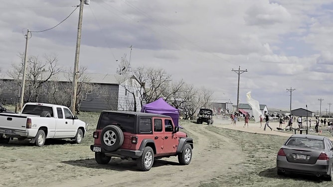 A dust devil picks up a canopy at a track meet in Whitewater, Montana.