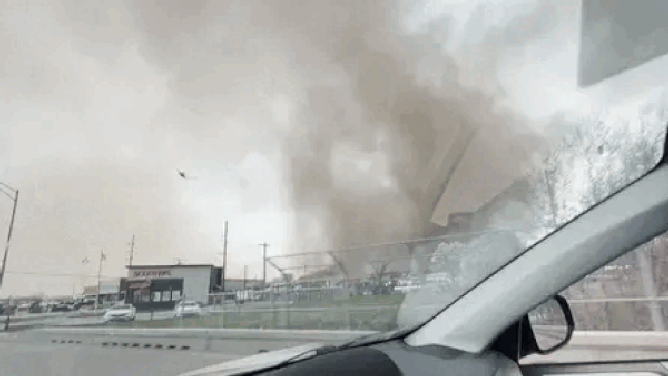 Video taken by Myles Nelson shows a column of swirling funnel cloud hover over buildings as a dust storm approaches in York, Nebraska, on Thursday.