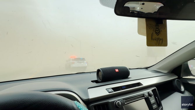 Video taken by Myles Nelson shows a column of swirling funnel cloud hover over buildings as a dust storm approaches in York, Nebraska, on Thursday.